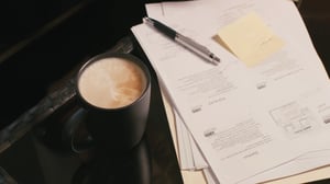 Taza de café y documentos de gestión que se utilizan en la producción ejecutiva | House of Films