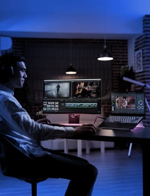 Persona en una computadora a dos monitores trabajando en la edición de una producción audiovisual | House of Films