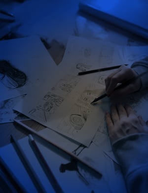 Persona dibuja esbozos de personajes en una hoja de papel para un storyboard. El ilustrador crea un guión para la realización de contenido audiovisual | House of Films