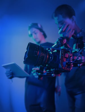 Cierre del operador con cámara profesional durante la grabación con el director que controla el proceso | House of Films