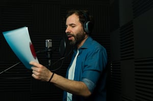 Persona grabando un audio en voz en off en una cabina de forma profesional House Of Films