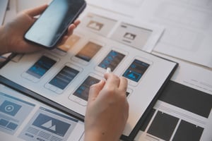 manos de una persona que está revisando las pantallas de una app