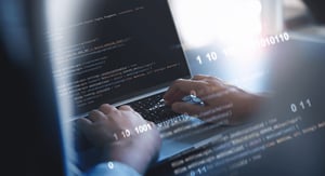 Manos de una persona trabajando en una computadora, mostrando código de programación. Neracode nos encargamos del desarrollo de proyectos tecnológicos en su totalidad.
