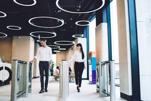 Hombre y mujer entrando a una empresa en checador digital
